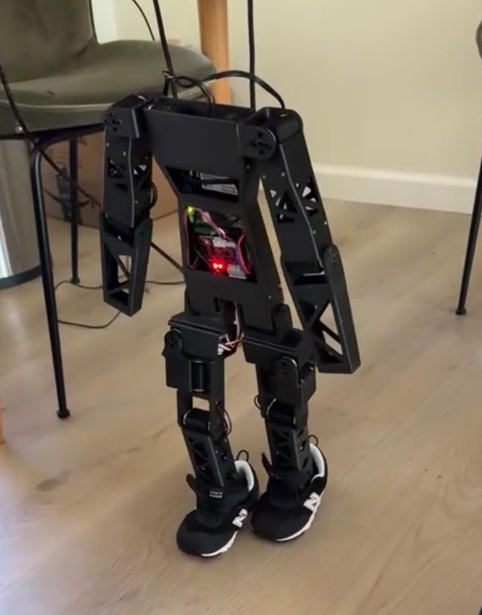 16 DOF mini humanoid robot standing in sneakers